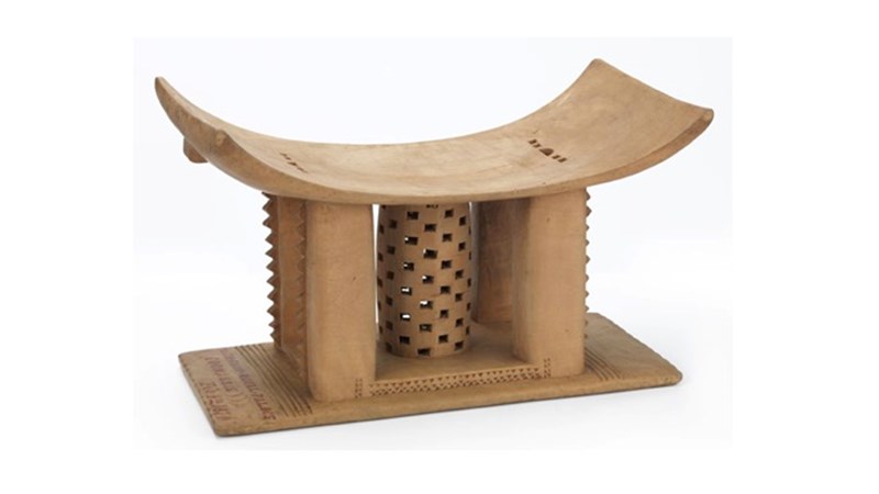 an ornately carved light coloured wooden construction which looks a bit like a stool