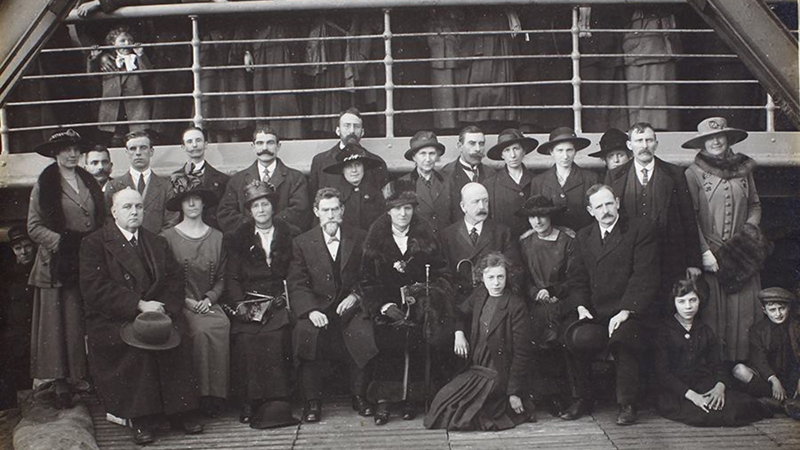 A black and white photo of several Belgian Refugees on a SS Khyber ship with members of the Belgian Relief Committee in 1919