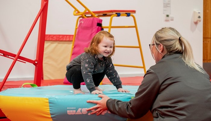 A gymnastics coach helping a child during a session