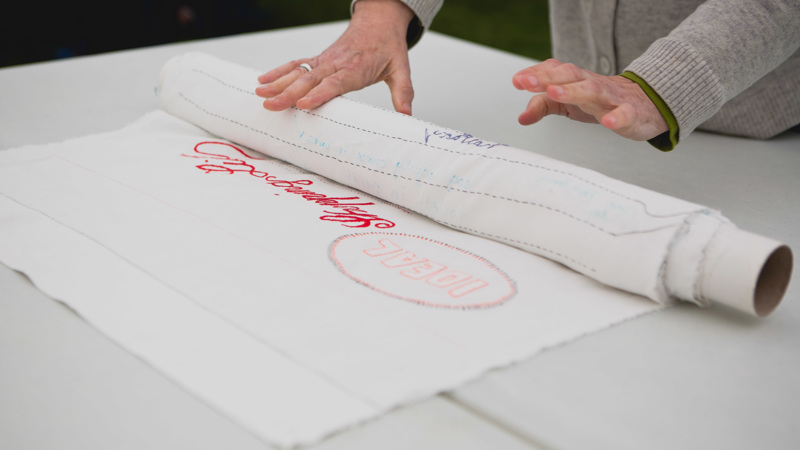 A large fabric art work shows stitched writing reading "An Idea Shopping List"