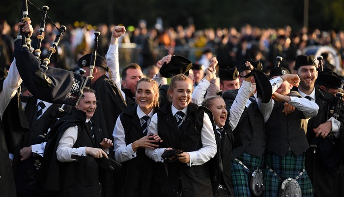 Picture of adults in a pipe band playing bagpipes and drums 