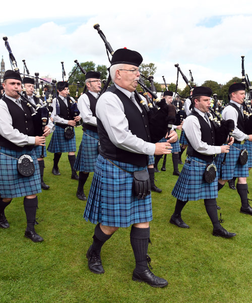 The procession of bagpipers march by, wearing blue kilts at World Pipe Band Championships