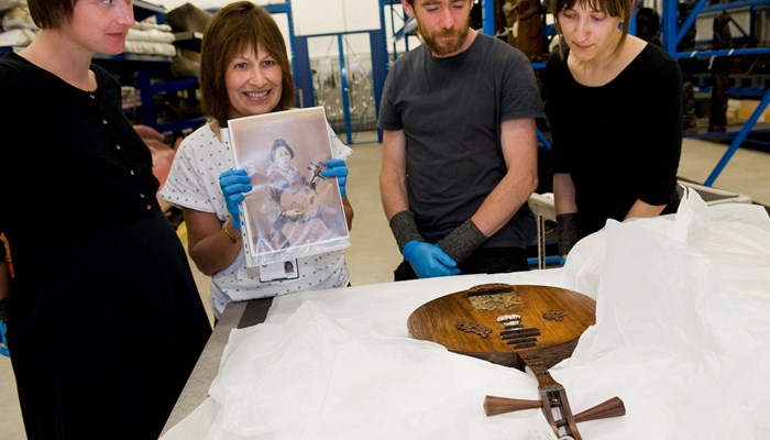 A group of four adults handling objects at a World cultures session at the Glasgow Museum Resources Centre