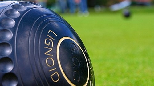 A close up of a black lawn bowling ball 