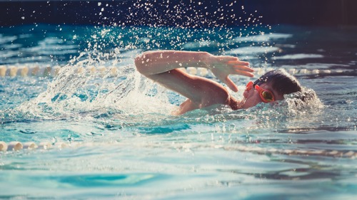 A boy swims in the pool