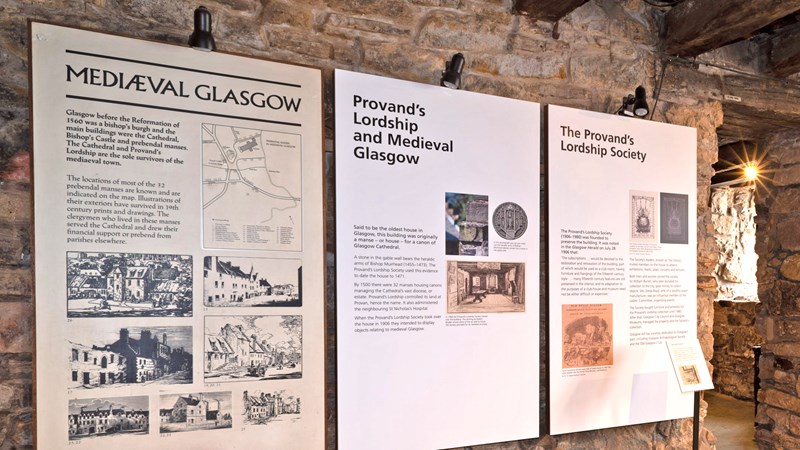 Photograph shows some mounted boards on the wall inside Provand's Lordship describing its history.