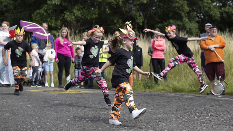 Children in costume, dance as part of an eco celebration