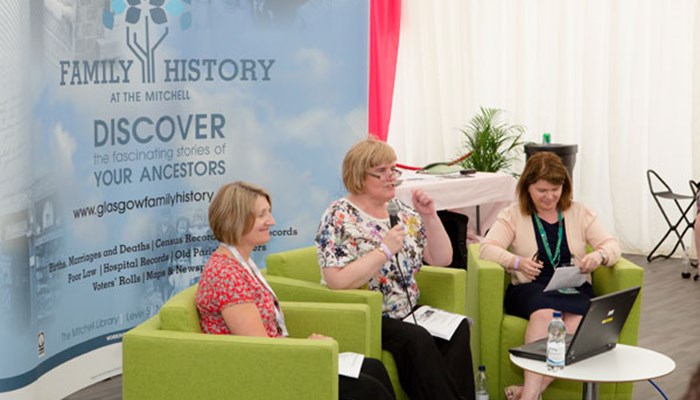A photo of a panel of experts from The Family History centre sitting on lime green chairs answering questions from the audience.