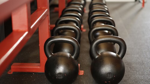 two rows of black kettle bell weights 