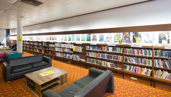 A seating area with leather couches in Hillhead Library. There are bookcases running along the back wall.