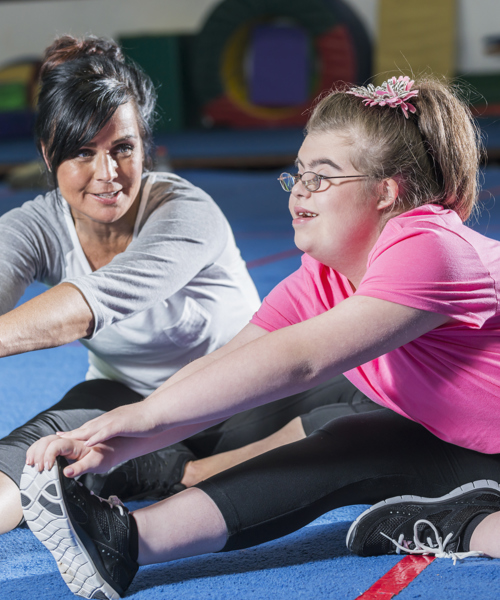 disabled girl stretching with her dance teacher