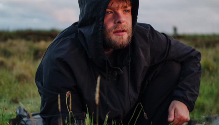 Artist Hammy Sgìth, posing in a rugged landscape