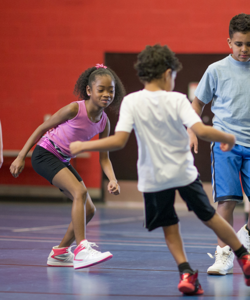 group of children playing football indoors