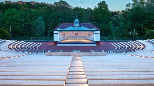 open ampitheatre with rows of seating surrounding a stage in the middle