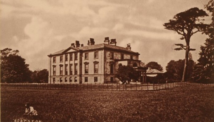 sepia photograph of a good-sized country home in a typical layout with a central atrium slightly protruding past two wings