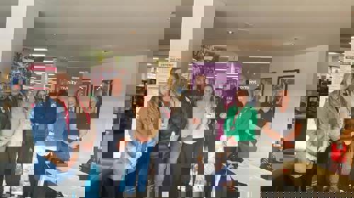 A group of eight people standing for a photo in a library