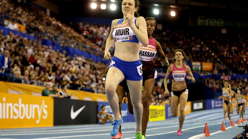 Female athletes running in an indoor stadium, the main women in the photo is Scottish athlete Laura Muir
