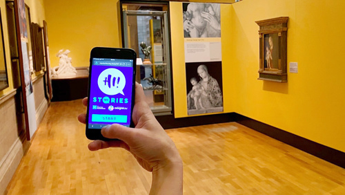 Photograph showing someone's hand using their phone to access My Stories Lite in Kelvingrove Art Gallery and Museum