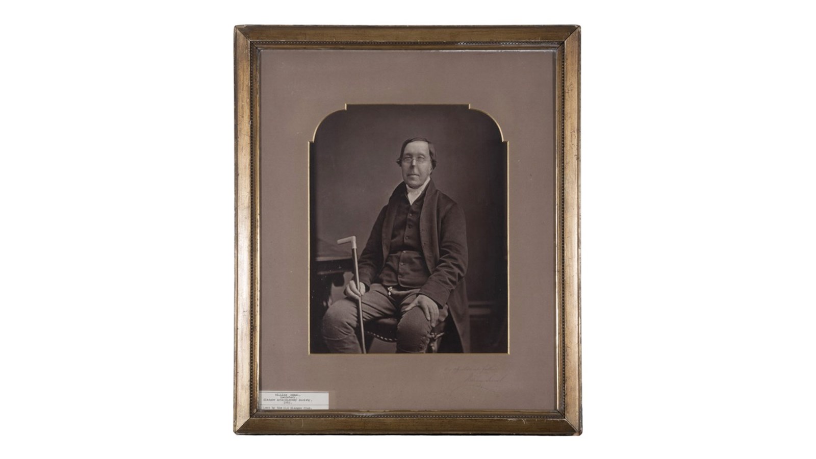 a framed early monochrome portrait photo of a person looking into the camera