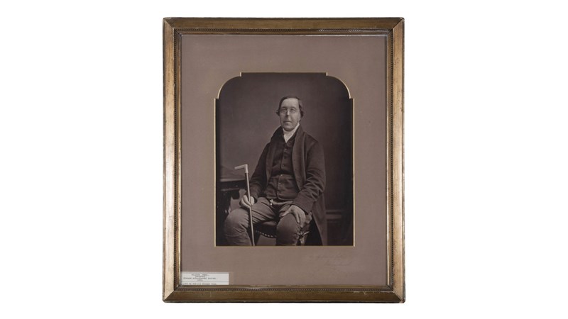 a framed early monochrome portrait photo of a person looking into the camera