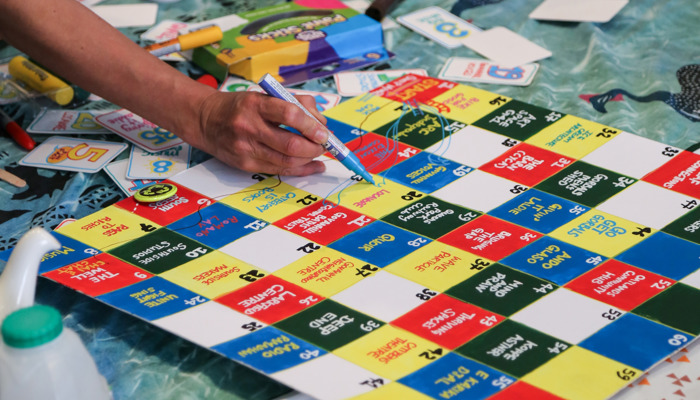 A close up someone playing a board game created by Swap Market. 