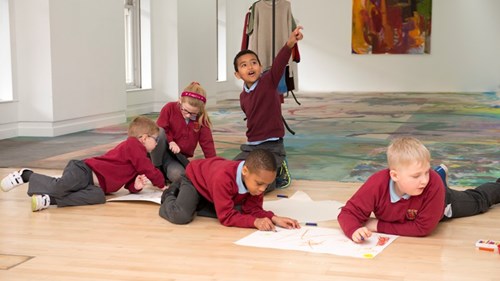 Five young children in school uniform take part in a creative workshop 