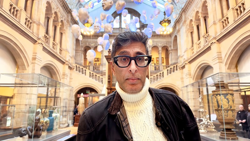 Photograph showing the actor, writer and presenter Sanjeev Kohli standing inside Kelvingrove Art Gallery and Museum