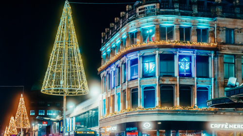 Colourful festive lights in the windows above a city centre coffee shop