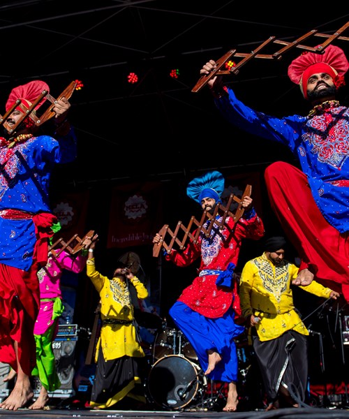 people dancing in bright clothing on stage 