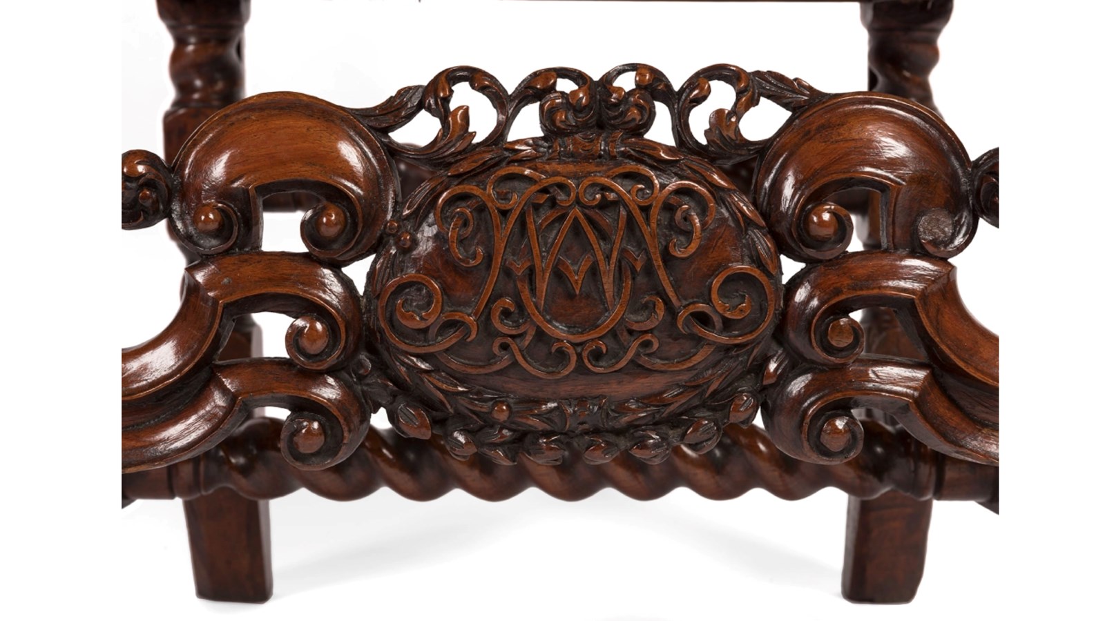 detail shot of a monogram on an ornate dark wooden chair
