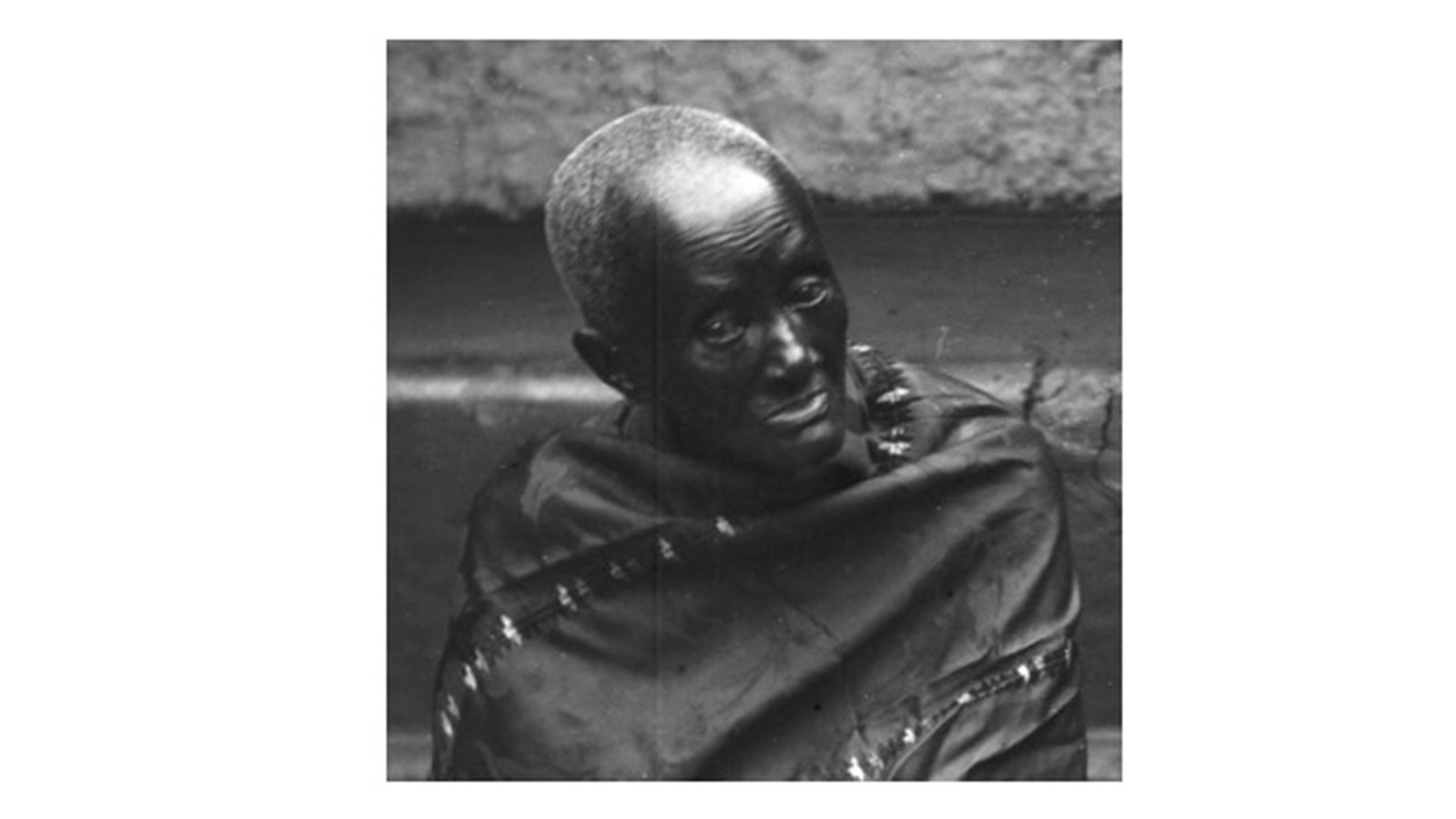 a black and white image of a figure in a dark cloak.