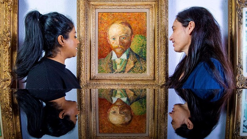 Photograph showing two young women standing looking at a Van Gogh painting hanging on a museum wall