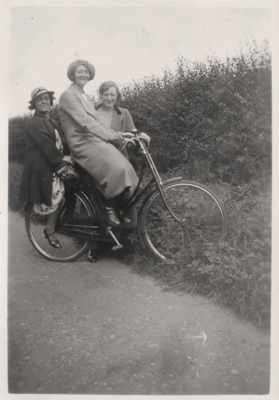 Three female friends pictured in 1937 with a Raleigh bicycle on a country road