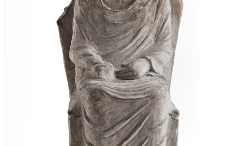 Ancient Greek clay figure of a woman sitting on a high-backed throne