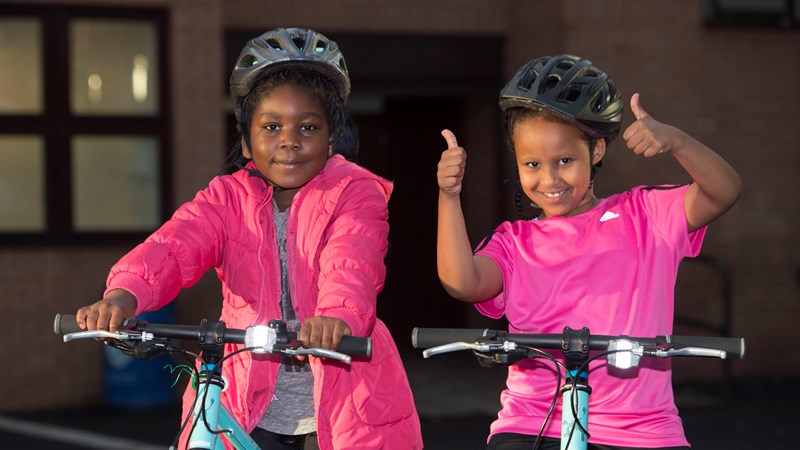 Two young children on bikes smiling