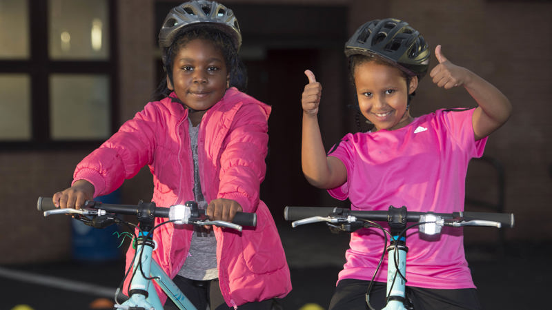 Two young children on bikes smiling