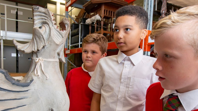 Photograph showing young people looking at a sculpture in a museum store