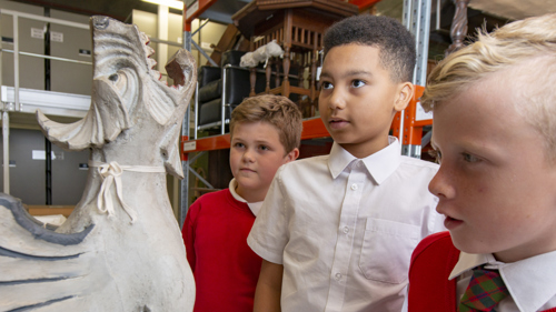 Photograph showing young people looking at a sculpture in a museum store