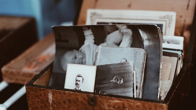 Wooden box of ephemera including newspaper clippings and black and white photographs