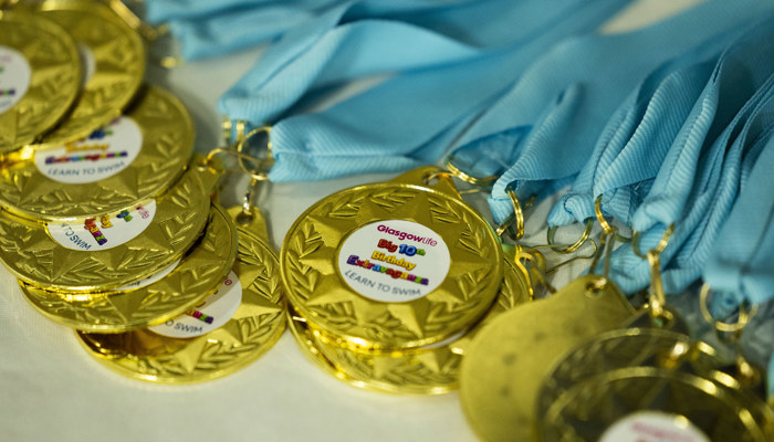 Learn to Swim anniversary medals displayed at the Glasgow Life celebration event.