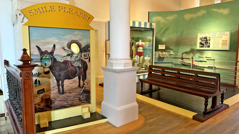 Photograph showing a classic seaside 'cutout' featuring a donkey and a child enjoying a ride.