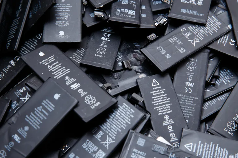 an image showing discarded black iPhone batteries in a heap