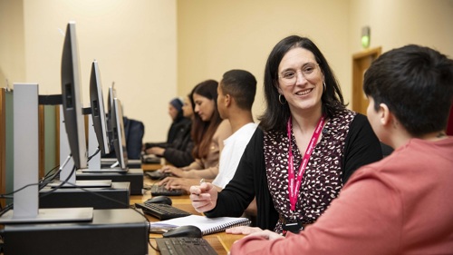 A group of people sitting at computers in a classroom