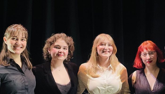 An image of four people stood in a row 