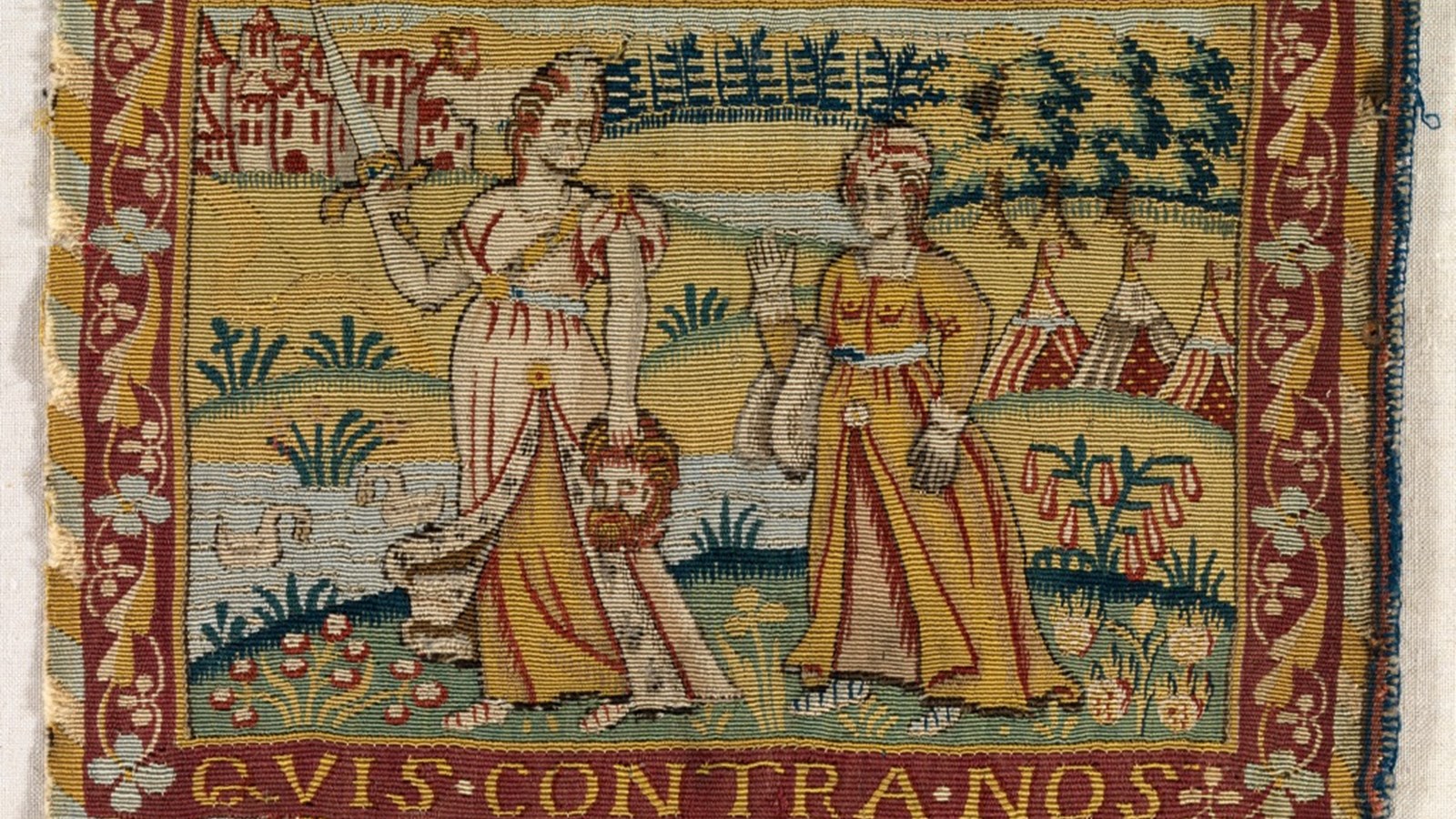 tapestry showing a person holding a decapitated head whilst another person looks on