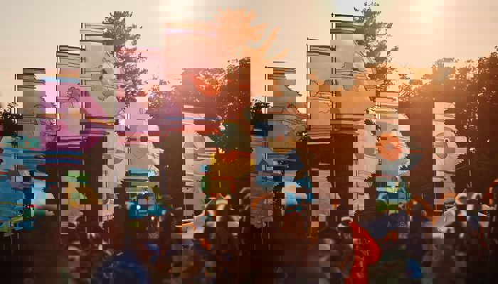 Music fans enjoy a festival as multicoloured flags fly above