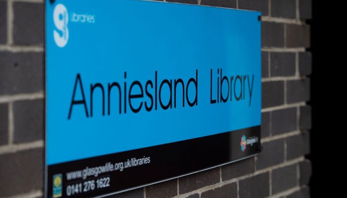 Anniesland Library outdoor signage. The background is in blue with black text.