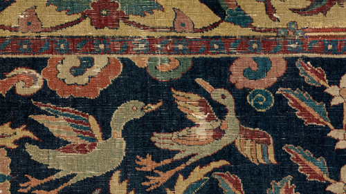 Close up detail of a tapestry featuring small flying ducks