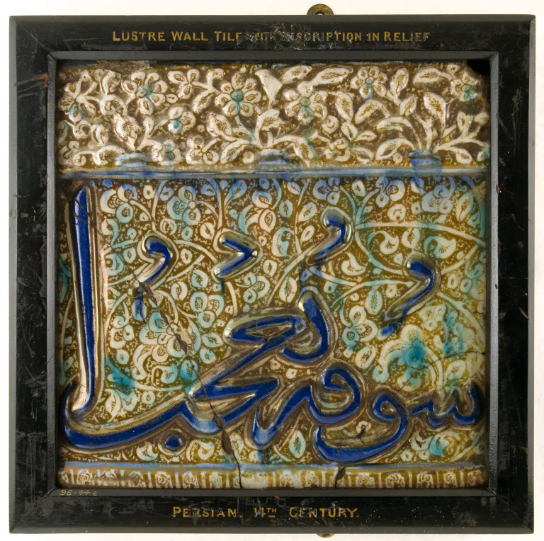 a photograph of a tile inlaid with cobalt. It features Persian patterns and blue inlays.