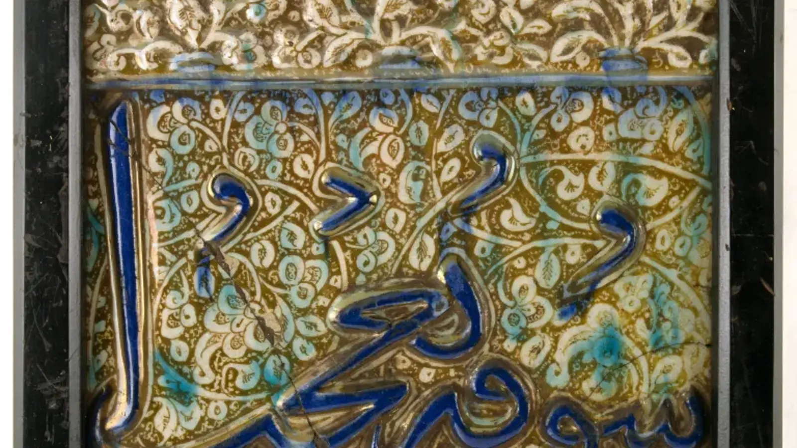 a photograph of a tile inlaid with cobalt. It features Persian patterns and blue inlays.